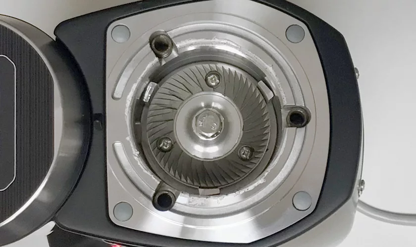 Close-up view of the Mazzer Super Jolly V Pro Espresso Coffee Grinder’s burrs, highlighting sharp circular metal blades, screws inside the machine, and coffee residue around the edges. © 2025 1st-line.com