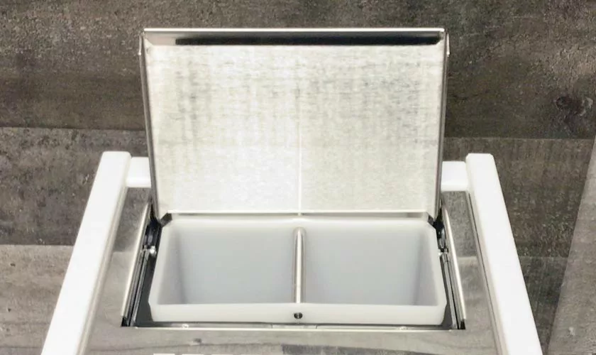 A stainless steel ice bin with a hinged lid is open to show two white compartments inside. Perfect next to your Stone HX Espresso Machine, the bin sits against a gray textured background. © 2025 1st-line.com