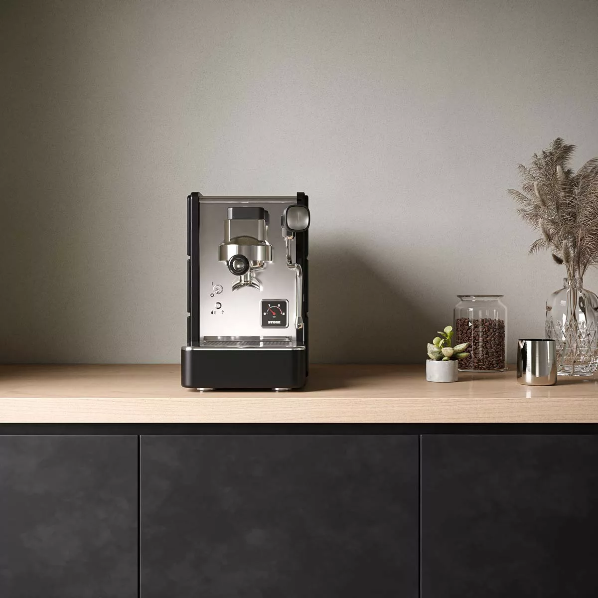 The Stone HX Espresso Machine rests on a light wooden countertop with glass jars, a potted succulent, and dried grasses—creating an inviting coffee corner against a neutral wall. © 2025 1st-line.com