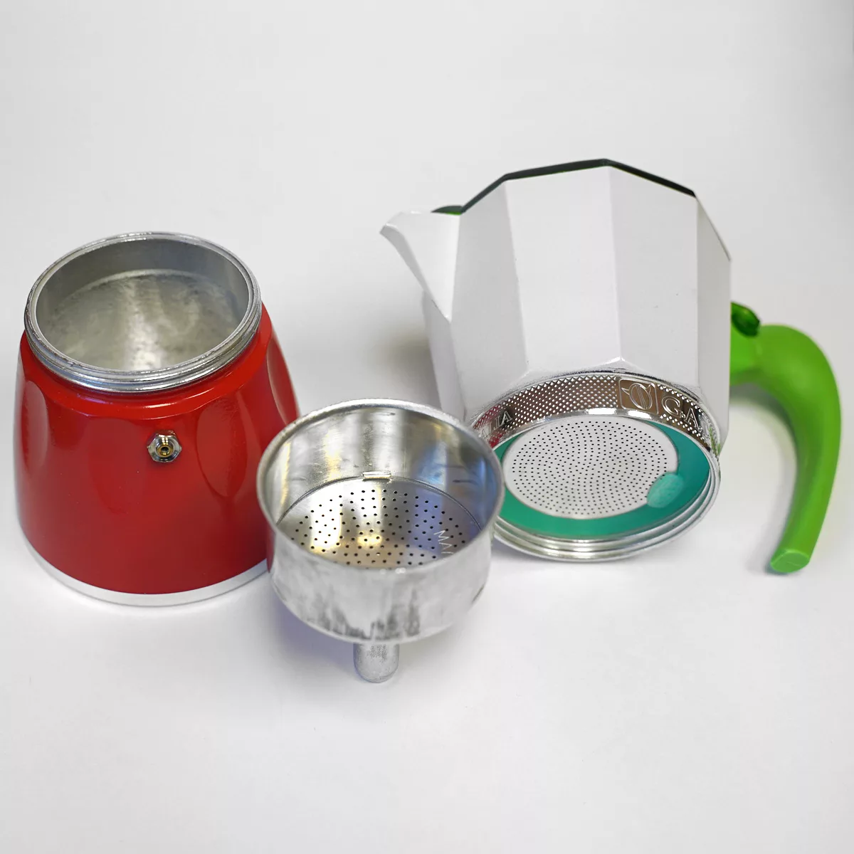 A disassembled G.A.T. Italian Stovetop Moka Pot, featuring a red base, metal filter, silver upper chamber, and green handle, sits on a white surface. © 2025 1st-line.com
