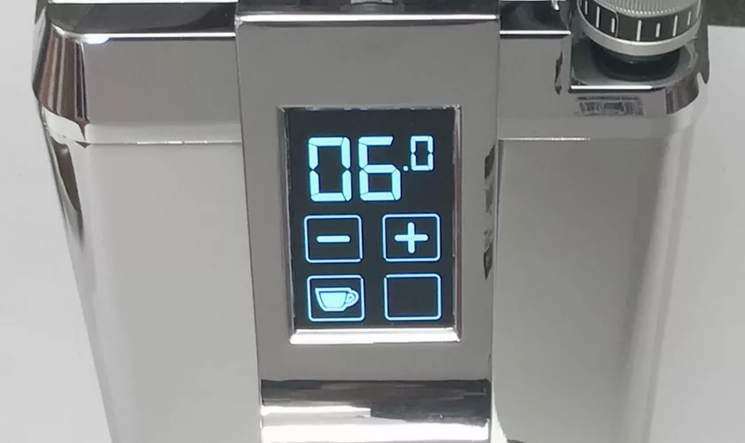 A close-up of a digital display on the shiny Faema TOUCH & MATCH Espresso Coffee Grinder shows “06” and several touch buttons, including plus, minus, and a coffee cup icon—perfect for your modern coffee setup. © 2025 1st-line.com