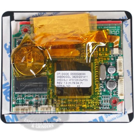 A close-up of the Quamar RMTP00001 Display Board M80/TP shows electronic chips and capacitors, partially covered with yellow-orange protective film and mounted on a 3M adhesive sheet. © 2025 1st-line.com