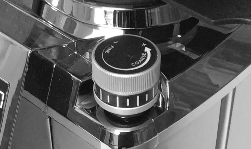 Close-up of the Faema TOUCH & MATCH Espresso Coffee Grinder’s adjustment knob labeled “FINE” and “COARSE,” with arrows for grind size direction on its shiny, metallic surface. © 2025 1st-line.com
