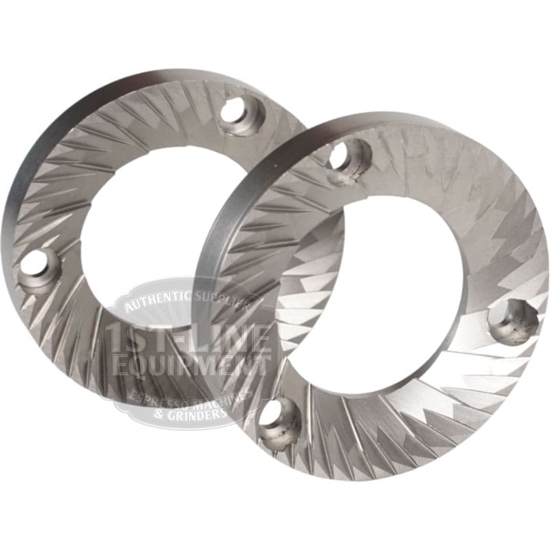 Set of two Quamar 260017 54 mm Q50 Grinding Burrs, each with sharp angled ridges and three mounting holes, are arranged overlapping on a white background. © 2025 1st-line.com