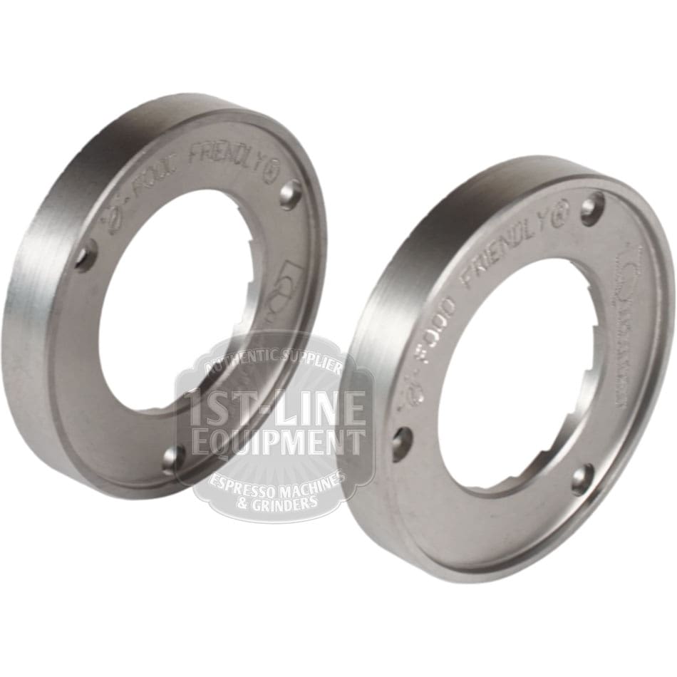 The Quamar 260017 54 mm Q50 Grinding Burrs - Set of 2 are shown side by side on a white background, featuring engraved text on the edge, a circular shape, inner cutouts, and mounting holes. © 2025 1st-line.com