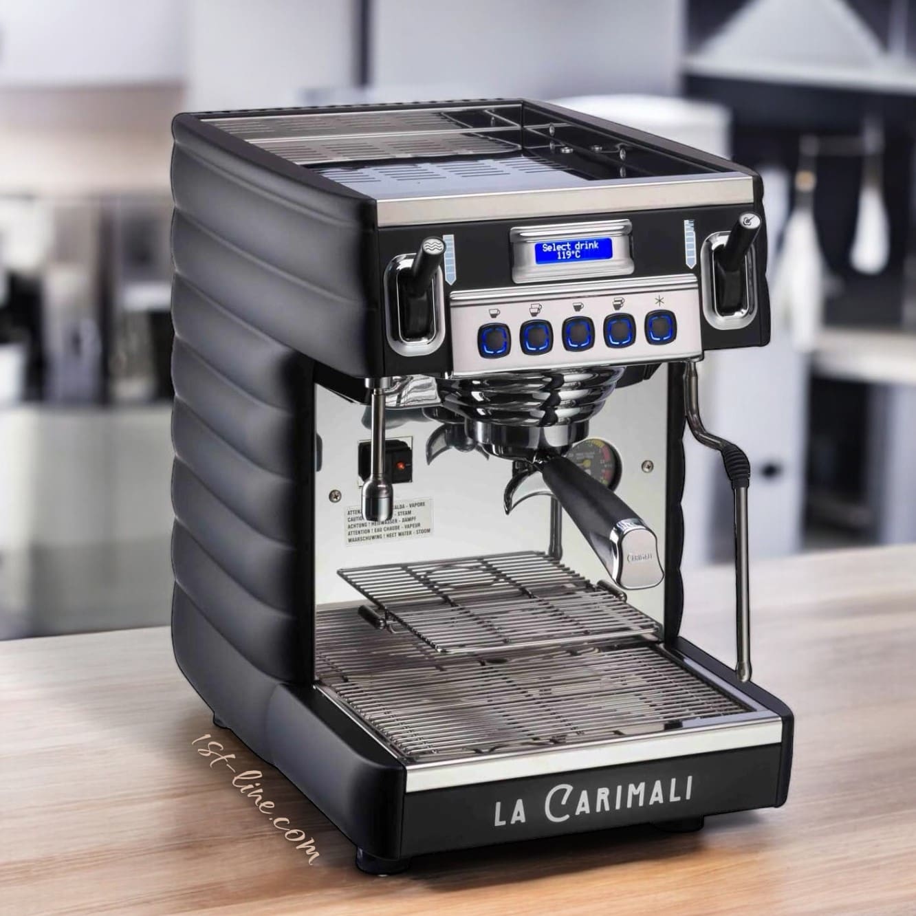 A Carimali Bubble 1 Group Commercial Espresso Machine (110V) with a digital display and control buttons sits on a wooden countertop in a bright, blurred kitchen. © 2025 1st-line.com