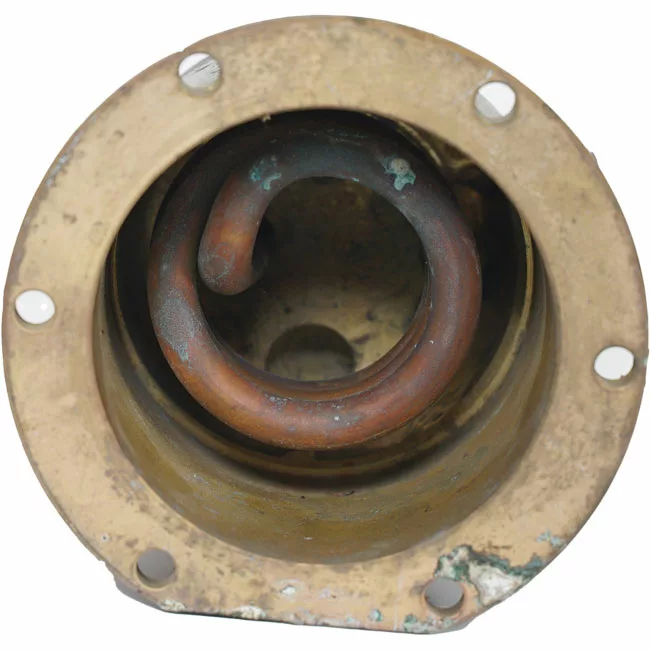 A close-up of a coiled copper pipe inside a round, weathered fitting with five bolt holes shows tarnish and corrosion—features typical of the Rancilio 20102944 230V Boiler with Welded Element. © 2025 1st-line.com