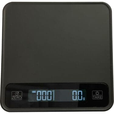 A Eureka Precisa Digital Scale features a black surface, backlit display reading “0.0 g,” and control buttons for Zero and Tare located below the display on the left and right sides. © 2025 1st-line.com