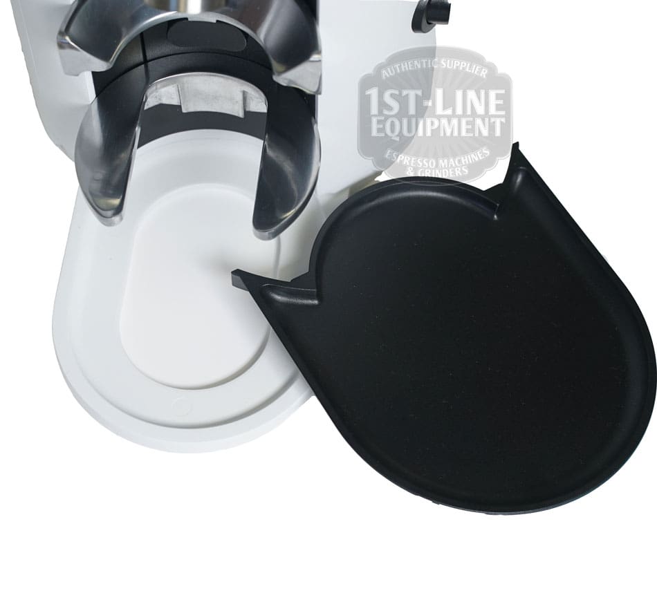 Close-up of the Mahlkonig X54 Allround Home Grinder shows its white base, removable black drip tray, and metallic spout. The 1st-Line Equipment badge is visible in the background. © 2025 1st-line.com