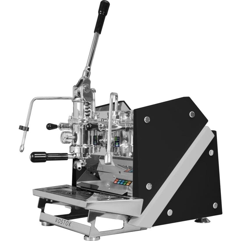 A professional ACS Vostok Lever Espresso Machine with a manual lever, black and silver body, multiple handles, and shiny metallic components sits on a stainless steel drip tray. The brand Vostok is visible on the front. © 2025 1st-line.com