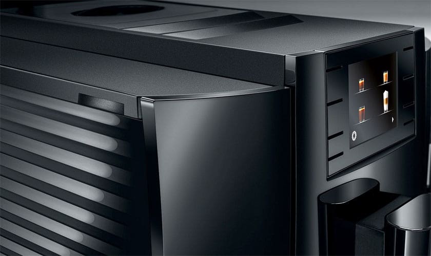 Close-up of the Jura E8 Super-Automatic Espresso Machine, featuring a sleek, glossy design and a digital touchscreen display with various drink options. © 2025 1st-line.com