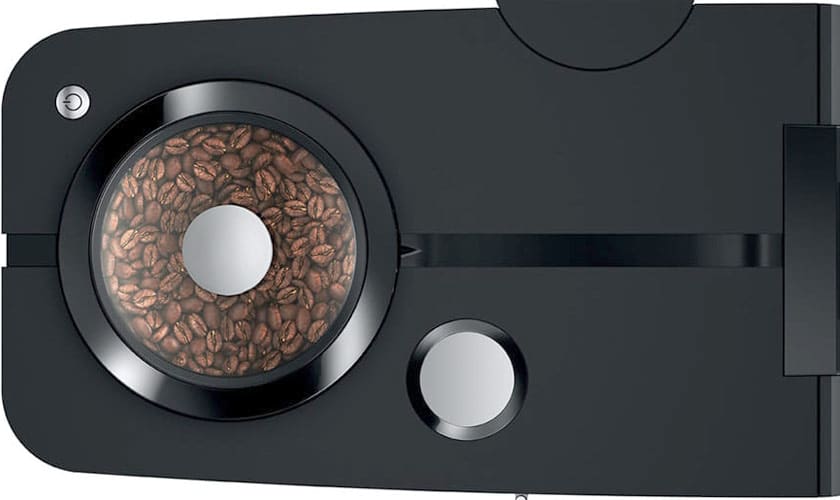 Close-up of the Jura ENA 8 Super-Automatic Espresso Machine, featuring a transparent bean compartment filled with whole beans, a sleek black finish, and metallic accents for a modern touch. © 2025 1st-line.com