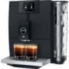 The Jura ENA 8 Super-Automatic Espresso Machine features a sleek black and silver design, digital drink selection, two glasses of coffee on the drip tray, and a right-side water reservoir. © 2025 1st-line.com