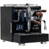 A sleek, black espresso machine with chrome and wooden accents, featuring multiple spouts, a pressure gauge, and a digital display screen on the front panel. The machine is branded Torre. © 2025 1st-line.com
