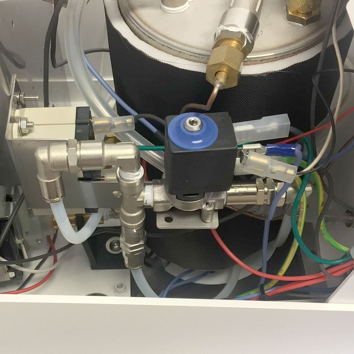 Close-up of the Nurri R-Type SB (HX) Espresso Machines interior, highlighting the central blue solenoid valve, HX system, metal pipes, valves, tubes, and colorful wires that demonstrate its precise engineering. © 2025 1st-line.com