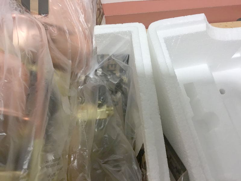 A close-up view of items, including an Elektra Semi-Automatica, packaged in clear plastic and surrounded by white foam packaging inserts inside a cardboard box, illustrating careful repackaging. © 2025 1st-line.com