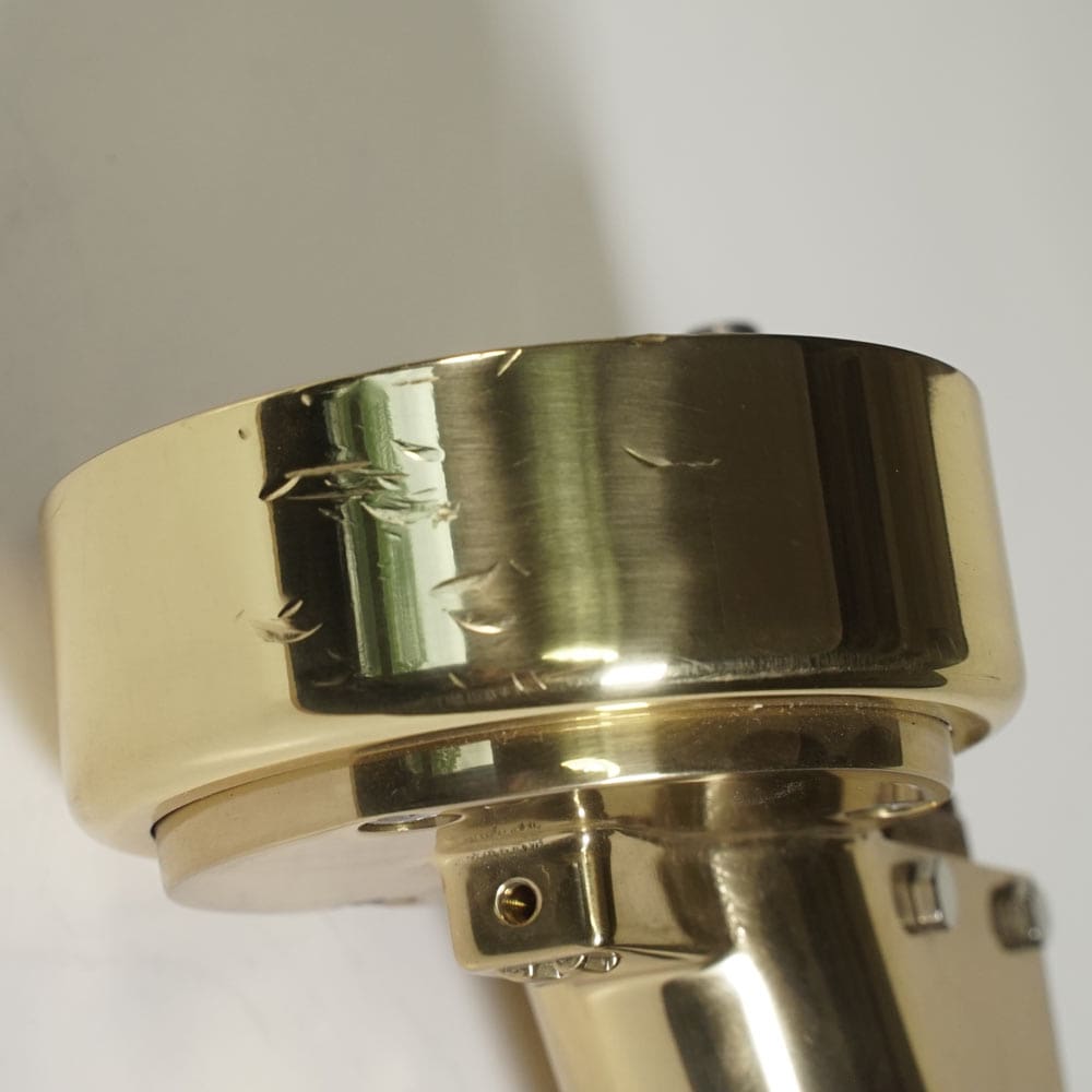 Close-up of a DAMAGED NEW Elektra rr02286038 Brass Complete Assembly Grouphead / Delivery Unit, showing multiple scratches and dents on its shiny surface, photographed against a plain background. © 2025 1st-line.com