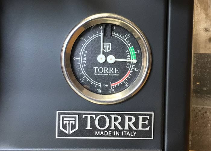 Close-up of a round pressure gauge on a black Torre Mariuccia Dual Boiler Espresso Machine w/ Flow Control, labeled TORRE Italian Coffee Machines, with the needle in the green zone and a TORRE MADE IN ITALY logo below. © 2025 1st-line.com