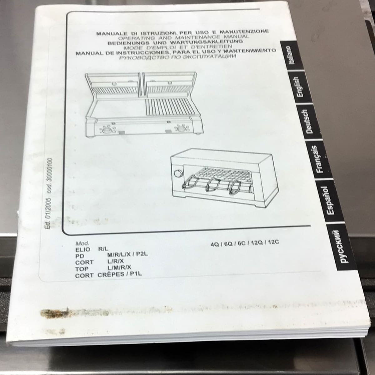 A multi-language manual for the SIDEWALK SALE - Sirman Panini Double Grill (E112) features a diagram and chart on the cover. Tabs for Italian, English, German, French, Spanish, and Russian are visible; there’s a stain at the bottom corner. © 2025 1st-line.com