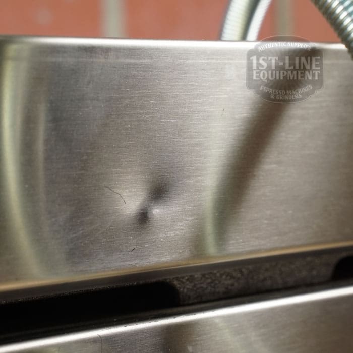 Close-up of a stainless steel espresso machine with a small dent, next to a SIDEWALK SALE - Sirman Panini Double Grill (E112). The 1st-Line Equipment logo appears in the upper right corner. © 2025 1st-line.com