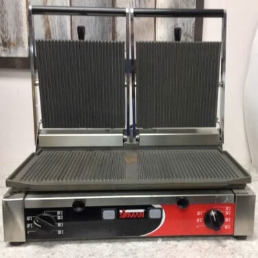 The SIDEWALK SALE - Sirman Panini Double Grill (E112) features ribbed top and flat bottom plates with red and black controls, ideal for grilling sandwiches quickly in any busy kitchen or sidewalk sale. © 2025 1st-line.com