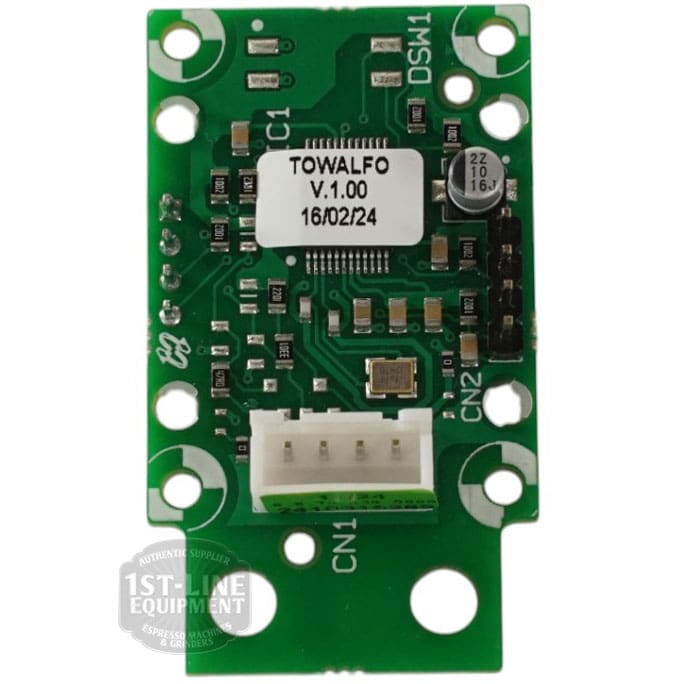 Close-up of a green PCB labeled “TOWALFO V1.00 16/02/24,” showing components and connectors for the Torre DISP0004 Display for Alfredo and Luigino TSP, compatible with Gicar 8.8.75.13G, with product references visible near mounting holes. © 2025 1st-line.com