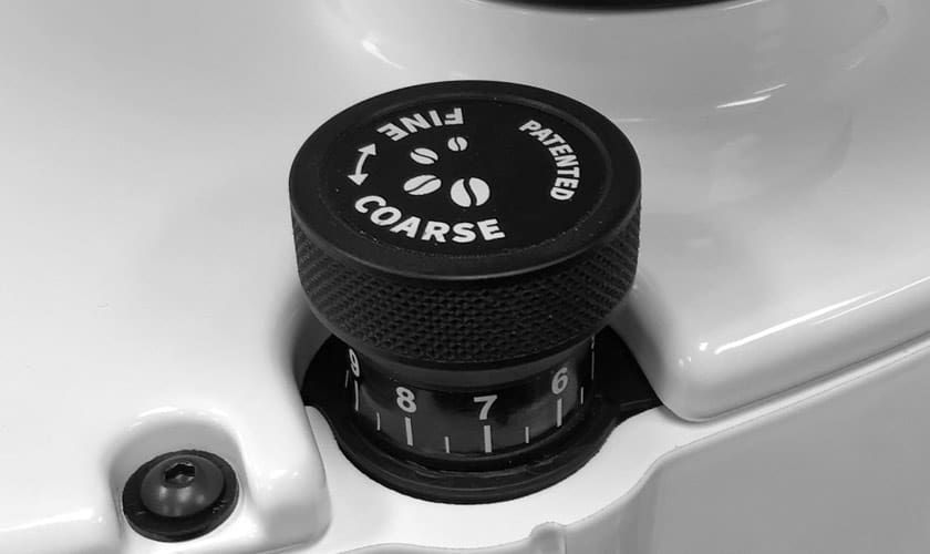 Close-up of the Eureka Atom W 65 Weight Based Espresso Coffee Grinder’s grind size adjustment knob, featuring COARSE, FINE, coffee bean icons, and numbers 6–9 on a textured white base. © 2025 1st-line.com