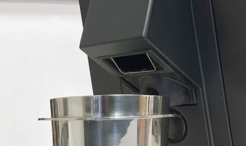 Close-up of the Eureka Mignon Single Dose Espresso Coffee Grinder dispensing ground coffee into a shiny metal container under the spout. © 2025 1st-line.com