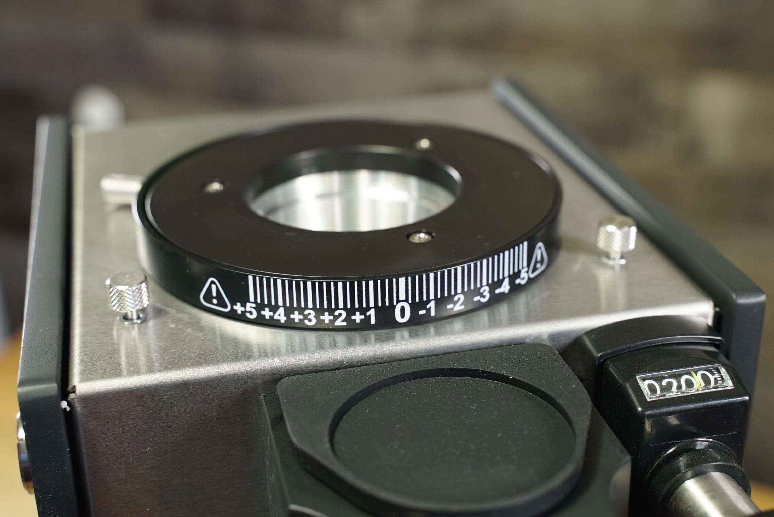 Close-up of the Slingshot Dosis S75 Espresso Coffee Grinder Black 220V, showing its metal build, circular dial with -5 to +5 white numeric markings, and precise controls for espresso grinding. © 2025 1st-line.com