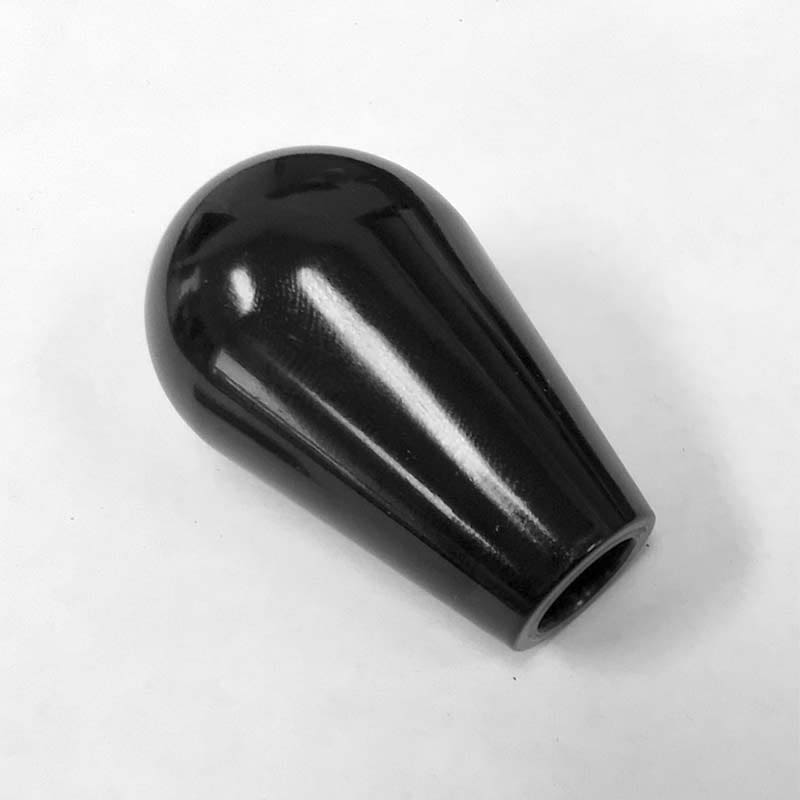 A glossy black, teardrop-shaped Bellezza Bellona object with a hollow opening at the narrow end, lying on a plain white surface, adds elegance and is the right fit for any modern decor. © 2025 1st-line.com