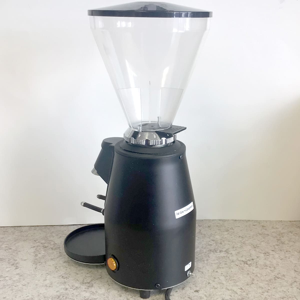 A SIDEWALK SALE 1st-line Sonny Espresso Coffee Grinder (used) (E113), black with a large clear bean hopper, sits on a gray countertop against a plain white wall—ideal for any coffee enthusiast. © 2025 1st-line.com