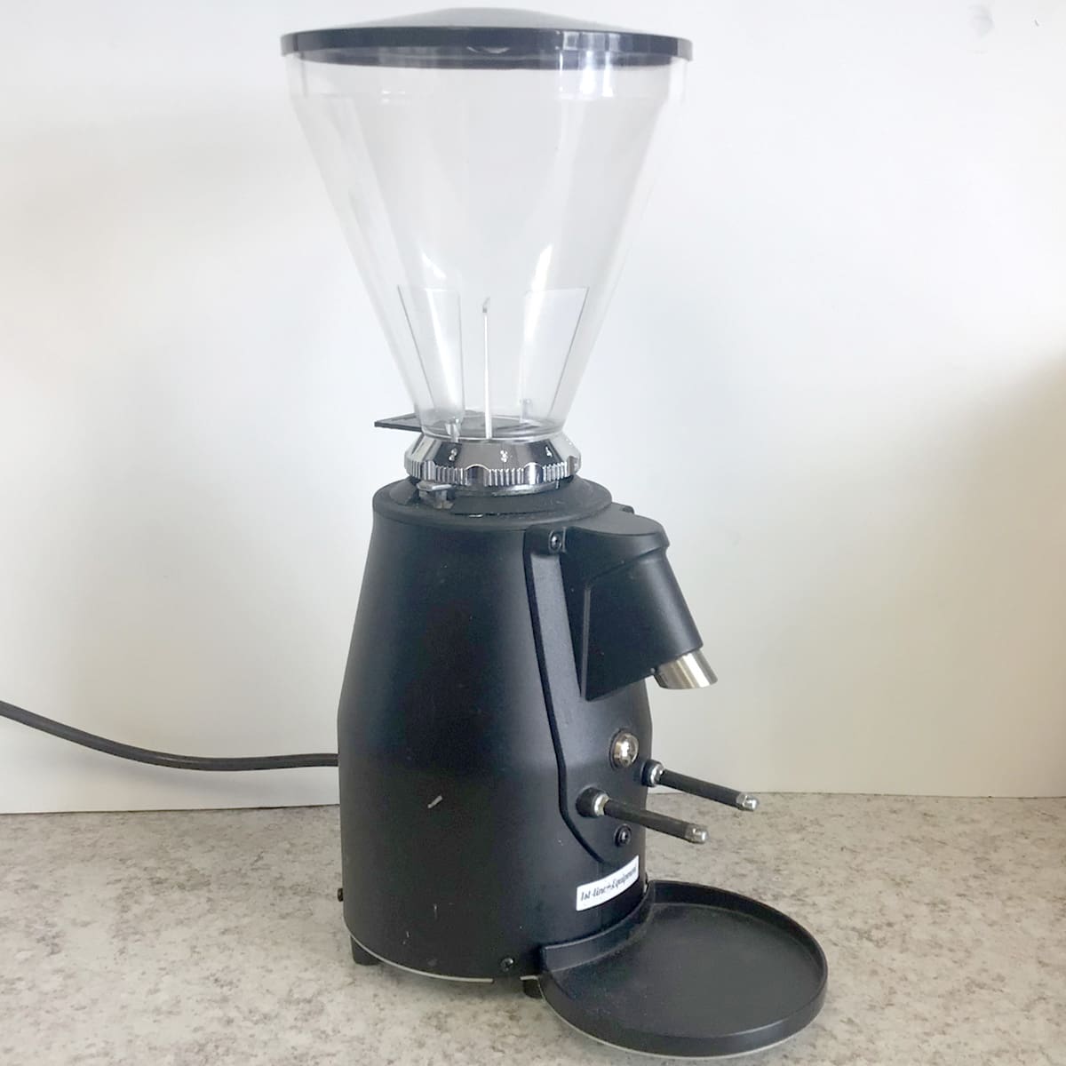 A used SIDEWALK SALE 1st-line Sonny Espresso Coffee Grinder (E113) with clear plastic hopper sits on a speckled countertop against a plain white background. © 2025 1st-line.com