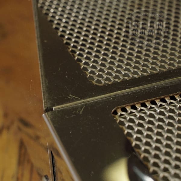 Close-up of a black metal mesh panel from a SIDEWALK SALE - VBM Domobar Super HX Tank Espresso Machine (USED) (E111), resting on wood. The photo highlights intersecting panel edges and reflections on the shiny metal. © 2025 1st-line.com
