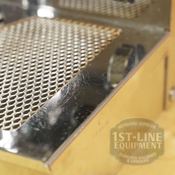 Close-up of a shiny metallic VBM Domobar Super HX Tank Espresso Machine (USED) (E111) drip tray with mesh grate. The 1st-Line Equipment logo and text appear faintly in the lower right, highlighting this gently used SIDEWALK SALE item. © 2025 1st-line.com