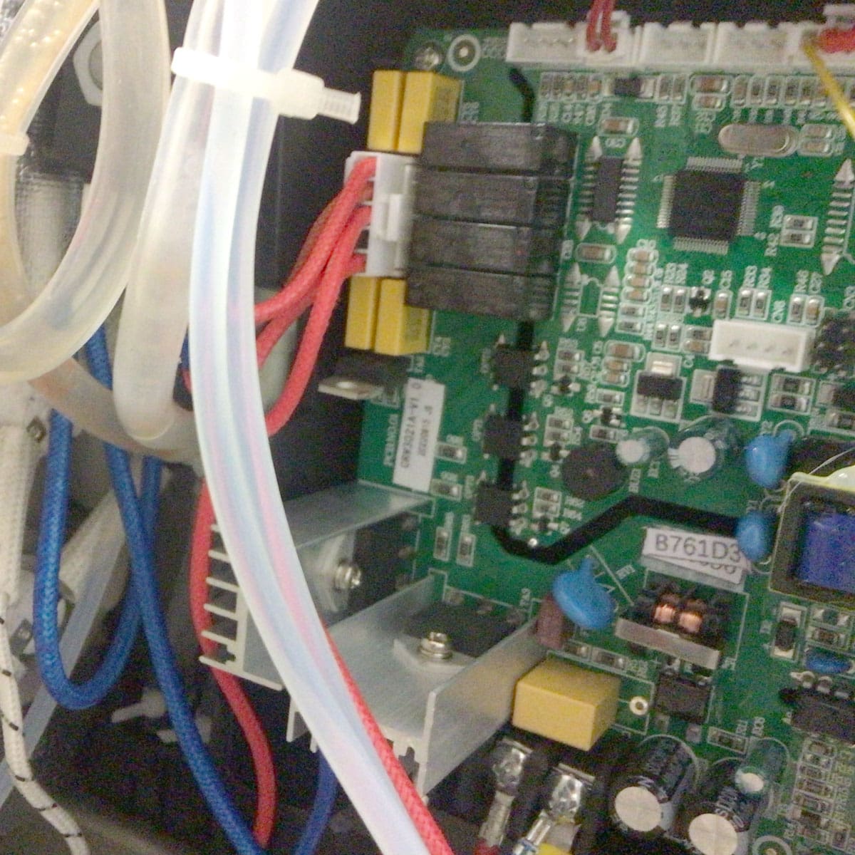Close-up of a Bellezza Inizio Mother Board with capacitors, resistors, relays, heat sinks, and colored wires. Clear and white plastic tubing runs alongside the electronic components. © 2025 1st-line.com