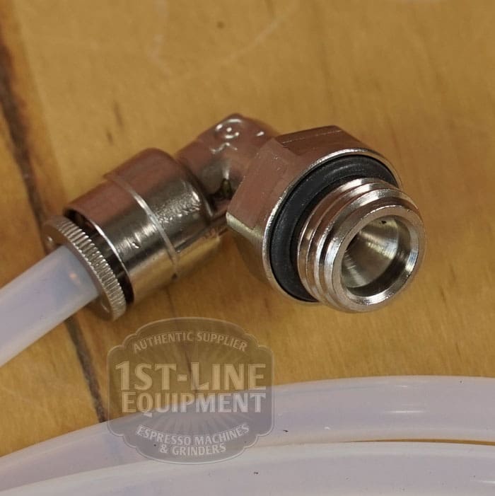 Close-up of a metal elbow fitting from the LIKE NEW - Elektra Verve Dual Boiler Espresso Machine (C104), attached to a clear flexible tube on wood. Fitting has a black rubber ring, threading, and 1st-Line Equipment watermark. © 2025 1st-line.com