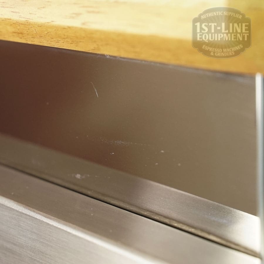 Close-up of the LIKE NEW - Elektra Verve Dual Boiler Espresso Machine (C104) with a small scratch on its metal and wood surface, featuring the “1st-Line Equipment” logo in the top right—it looks barely used. © 2025 1st-line.com