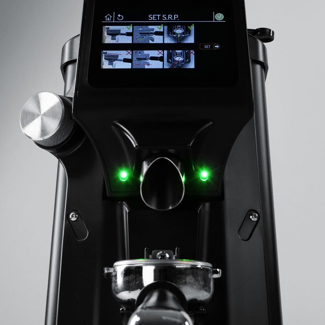 Close-up of the Quamar Alpha 65 Q Espresso Coffee Grinder with a digital display, two green indicator lights, portafilter holder, and a sleek black and metallic design. © 2025 1st-line.com