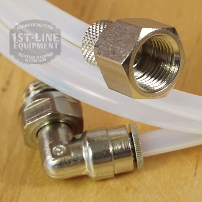 Close-up of two metal hose fittings attached to a clear tube on wood. A partial 1st-Line Equipment logo is seen behind—ideal for a LIKE NEW - Elektra Verve Dual Boiler Espresso Machine (C104) setup. © 2025 1st-line.com
