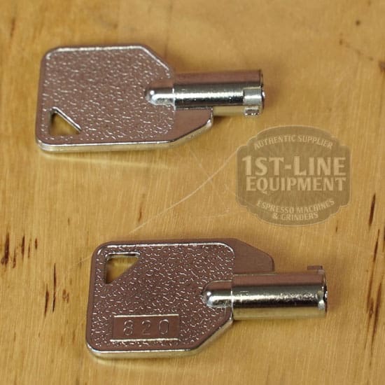 Two silver keys with square heads and round barrels rest on wood, one marked 820. In the background is the 1st-Line Equipment logo, featured with top machines like the LIKE NEW - Elektra Verve Dual Boiler Espresso Machine (C104). © 2025 1st-line.com