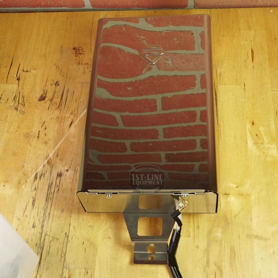 A Lelit 1000156 External Water Tank Assembly (E112) with a small dent and scratch sits on a wooden surface, showing electrical wiring and reflecting a red brick pattern. The “1st-Line Equipment” logo is visible. © 2025 1st-line.com