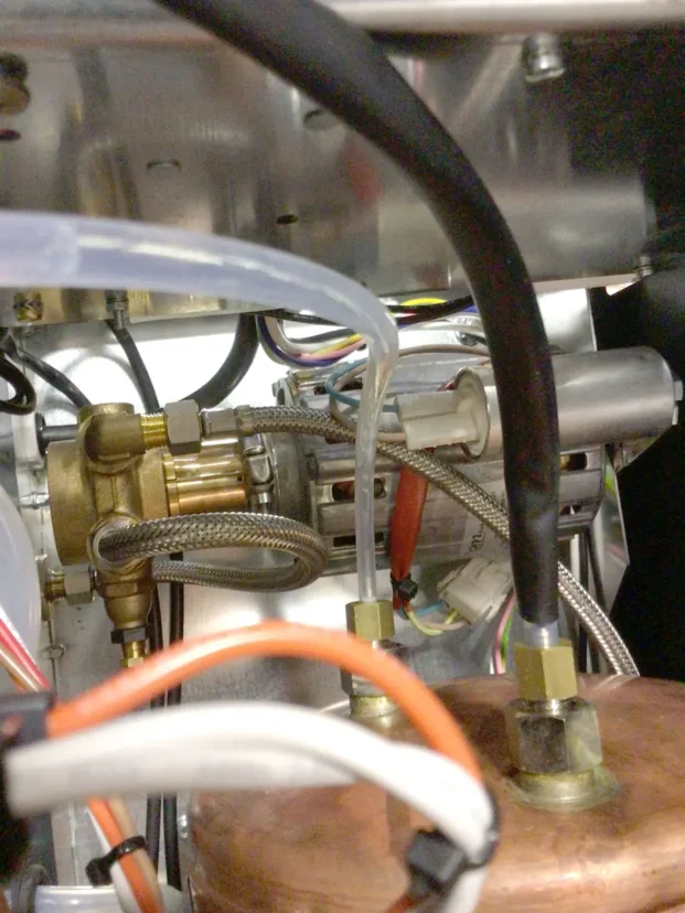 Close-up view of the internal components of a Carimali Bubble machine, showing metal pipes, wires, connectors, brass fittings, and a Swap Triac—likely part of a complex mechanical or electrical system. © 2025 1st-line.com