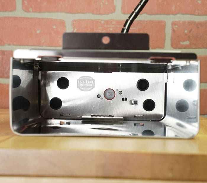 The Lelit 1000156 External Water Tank Assembly (E112) with a small dent & scratch is displayed against a brick wall on a wooden surface. © 2025 1st-line.com