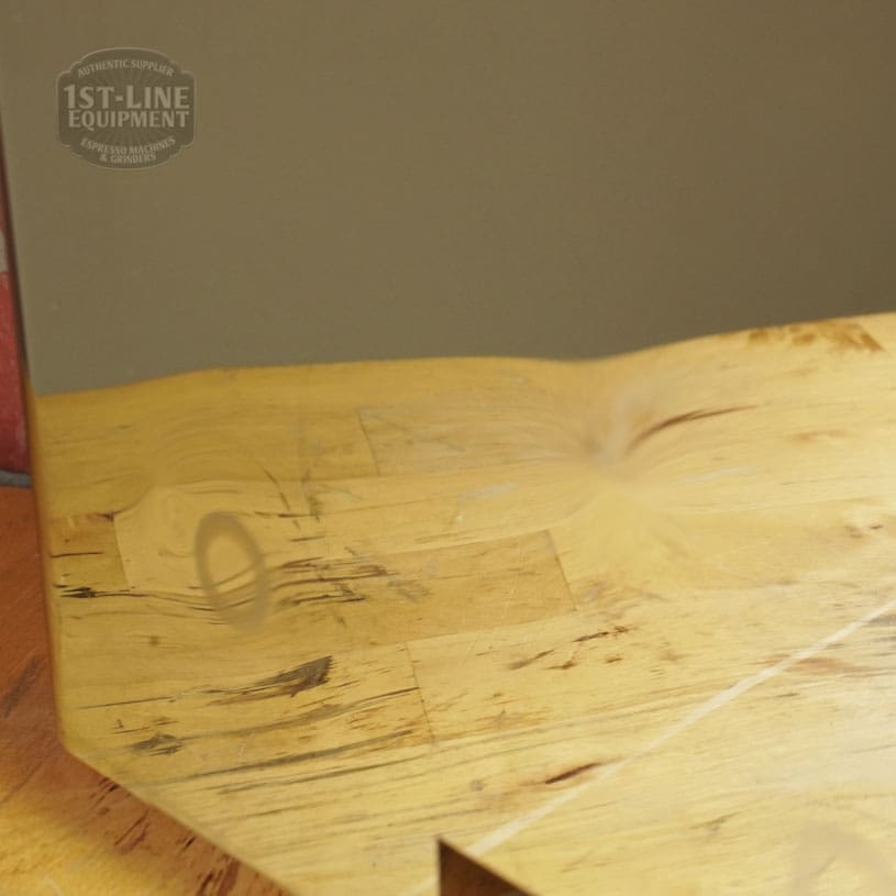 The Lelit 1400160 Back Body Panel (Dents) is made of stainless steel with a visible dent reflecting a wooden surface. The 1st-Line Equipment logo and the number 1400160 appear faintly in the upper left corner. © 2025 1st-line.com