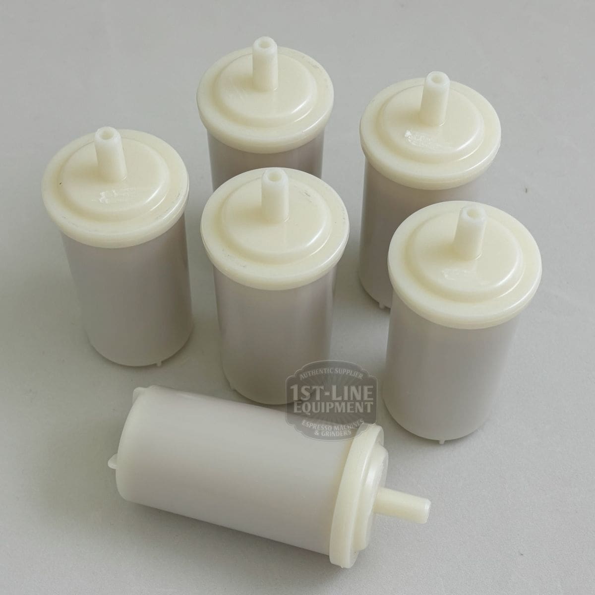 Six cylindrical 1st-line In Tank Water Softener / Particle Filter (30 liter) units with white plastic tops and nozzles are displayed on a light surface; five stand upright while one lies horizontally in front. © 2025 1st-line.com