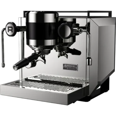 A shiny, stainless steel espresso machine with two group heads, steam wands, and a drip tray. The machine has a modern design with the brand name Rocket and model Bicocca visible on the front. © 2025 1st-line.com