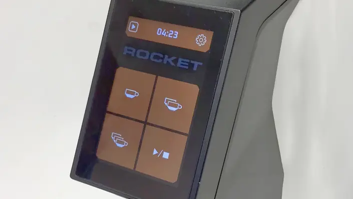 Close-up of a digital touchscreen display with the word “ROCKET” and four icons showing different cup sizes and a play/pause symbol, likely for controlling an espresso machine. © 2025 1st-line.com