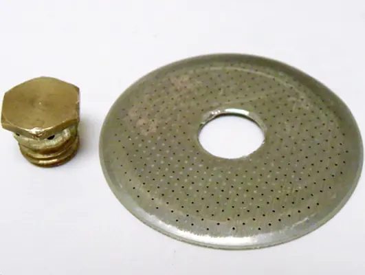 A brass screw and a round metal filter plate with small holes and a central opening, ideal as a dispersion screen upgrade for the Lelit PL41 Anna espresso machine, both placed on a white background. 2025 1st-line.com