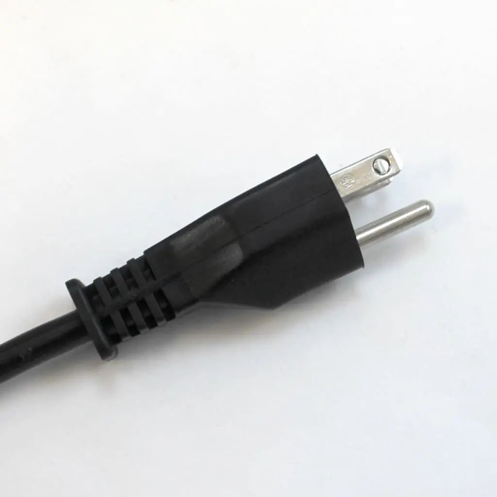 A close-up of a black, two-prong electrical power plug with a rounded shape—similar to those found on a Quamar Q50 coffee grinder—against a plain white background.