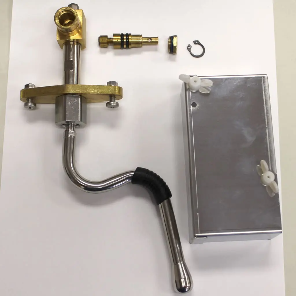 Various metal plumbing components, including a faucet, valve parts, a curved pipe, a metal box, and small hardware pieces, arranged neatly on a white background.